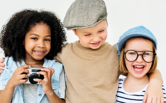 three young children of different races smiling and laughing together