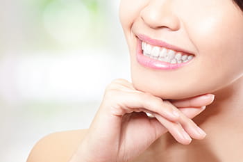 a lose up of a woman smiling showing her white smile after zoom whitening